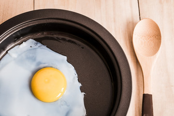 Fried egg and wooden spoon