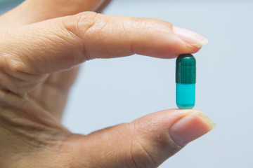 A woman holding pill capsules