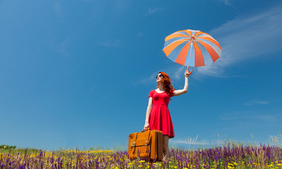 girl in red dress with umbrella and suitcase