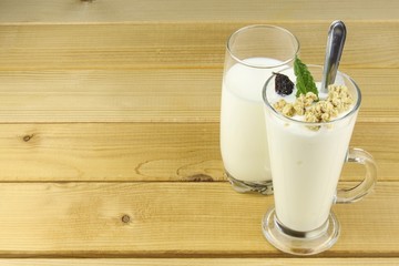 Glass of milk and yoghurt and muesli.