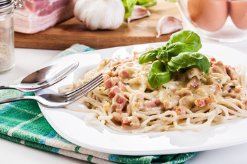 Spaghetti carbonara with bacon and basil