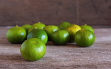 Fresh Green Lemons on Wooden Background.