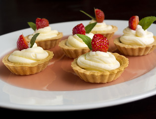 Cakes with strawberry, whipped cream, jelly and mint