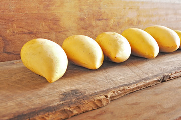 Mangoes in the Row on Wooden Background.