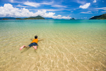 Fototapeta na wymiar man is swimming sea in sea and blue sky at Ranong, Thailand