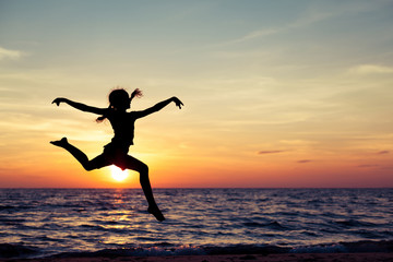 Happy girl jumping on the beach