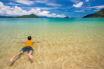 man is swimming sea in sea and blue sky at Ranong, Thailand