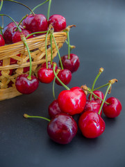 fresh red cherries on a basket on black background