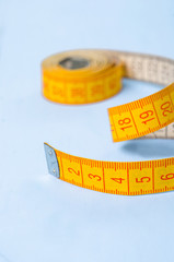 twisted tape measure on blue background