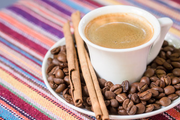 cup of coffee with cinnamon and beans