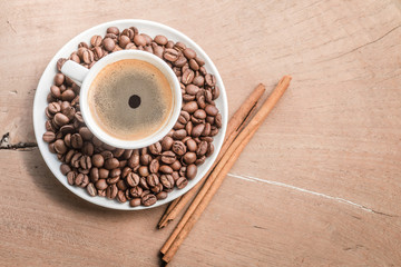 cup of coffee with cinnamon and beans