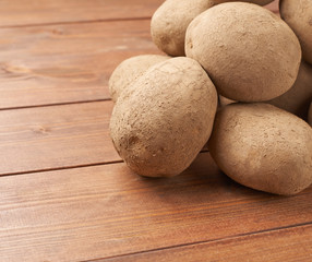 Fototapeta na wymiar Pile of potatoes over the wooden surface