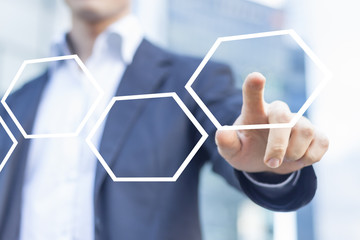Businessman touching hexagonal button in workflow with honeycomb pattern