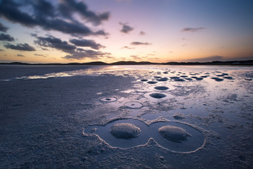 Cloudy sunset over quiet lagoon with interesting patterns from s