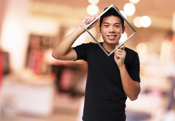 young chinese man looking through a frame