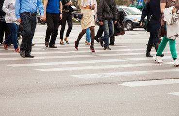 legs of pedestrians on a pedestrian crossing
