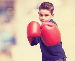 little kid fighting with red boxing gloves