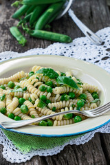 Italian Fusilli Pasta with holes with green peas, basil and lemon zest 