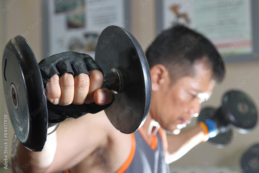 Wall mural muscular man working out with dumbbells