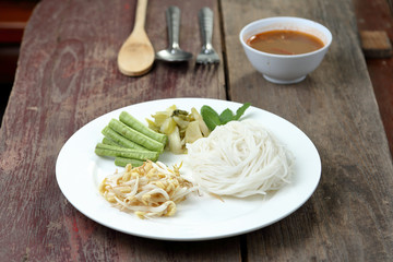 Thai rice vermicelli with vegetable on wood table.