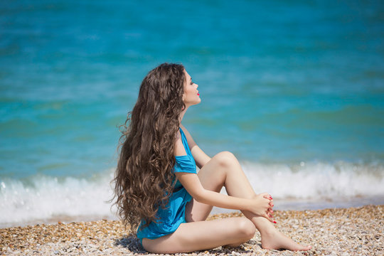 Young brunette girl enjoying and sunbathing on the beach with lo