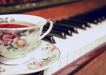A cup of tea and a piano in a vintage toning