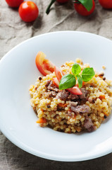 Cooked sardinain pasta fregola with tomato and sausage