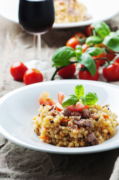 Cooked sardinain pasta fregola with tomato and sausage