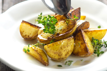Baked new potatoes with herbs on a wooden background