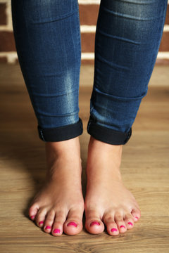 Beautiful female legs on wooden floor background