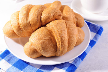 Delicious croissants on plate on table close-up