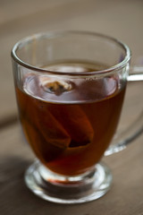 Glass cup of tea on a wooden table