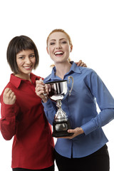 two business woman holding up a trophy