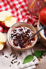 Apple jam and fresh red apples on wooden table close-up