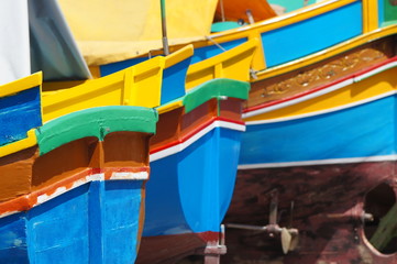 Fototapeta na wymiar alignement de poupes de Luzzu - bateau maltais à Marsaxlokk