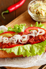 Hot-dog on wooden cutting board