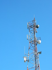Communication Tower with Parabolic and GSM Antennas, LTE and Blue Sky.