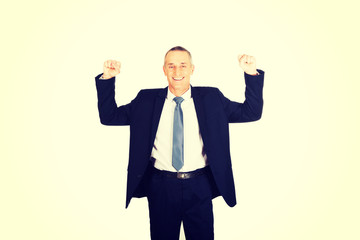 Portrait of successful businessman with arms up