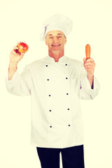 Male chef with an apple and carrot