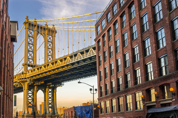 Manhattan Bridge between Brick Buildings at Sunset