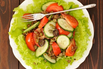 Lentil salad with tomatoes, cucumbers, capers and lettuce with t