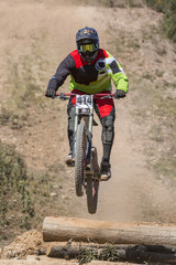 Downhill competition, Biker jumps fast in the countryside.
