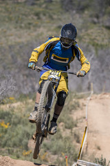Downhill competition, Biker jumps fast in the countryside.