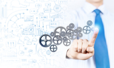 Businessman activating gears mechanism