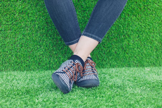 Feet of young woman on astro turf
