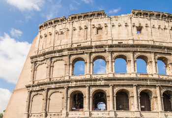 Obraz premium side view of the colosseum, one of the most important Heritage site from Roman empire, during a sunny day. Rome