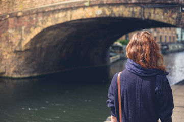 Fototapeta premium Young woman by bridge and canal
