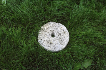 Old stone wheel on grass