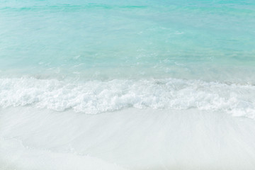Fragment of view of closeup white sand beach and turquoise ocean background