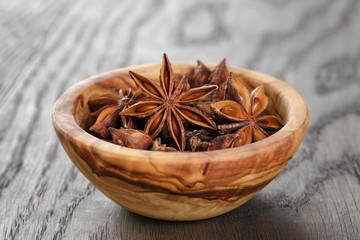 anise stars in bowl on old oak table close up photo